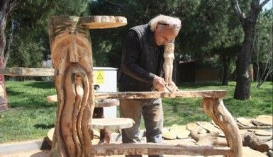 Ekmeğini kütükten çıkarıyor