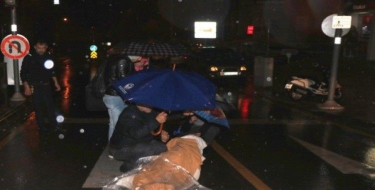 Motosikletten düşen kadını şemsiyelerle yağmurdan korudular