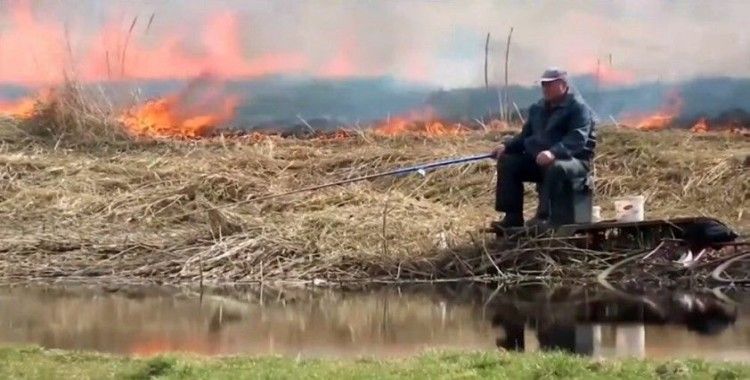 Yangına aldırmadan balık tutmaya devam etti